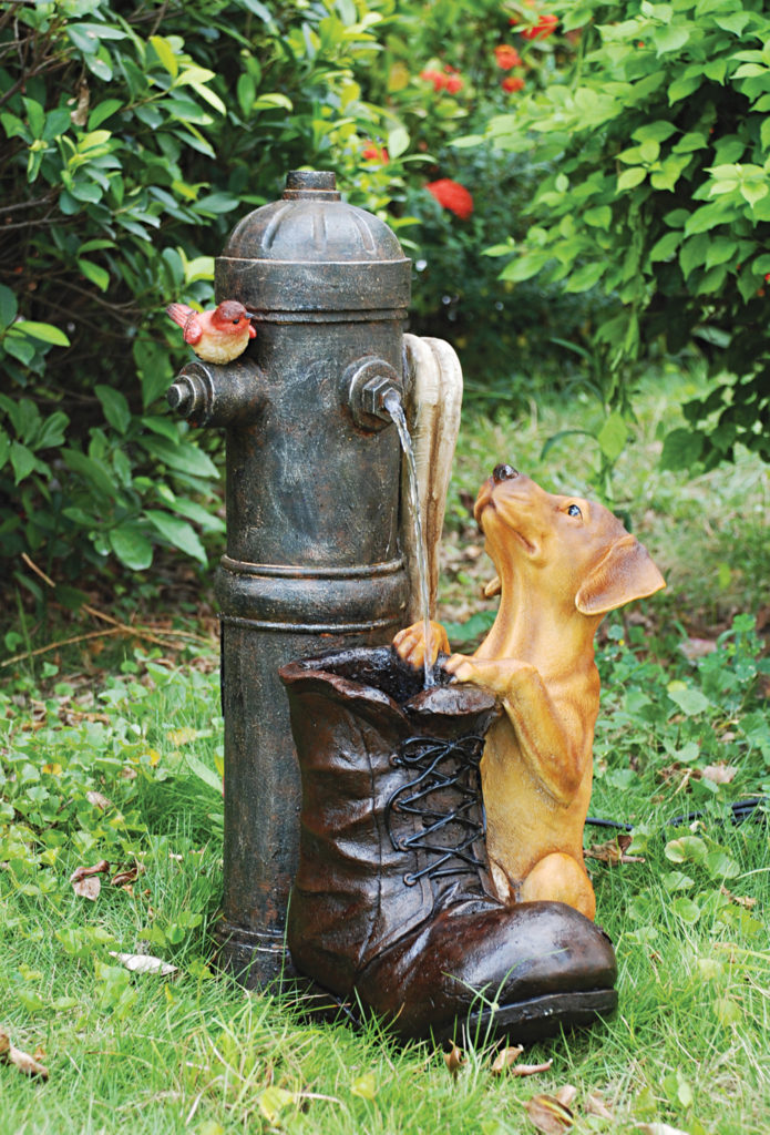 Fire hydrant fountain with dog and bird climbing on a boot