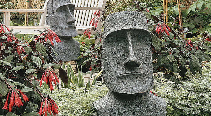 Moai's shown in a garden